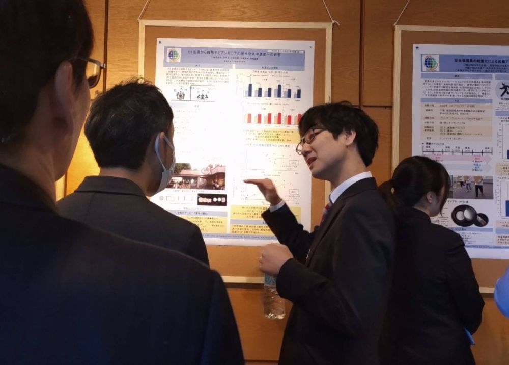 大学院生がポスターの前で熱心に解説している